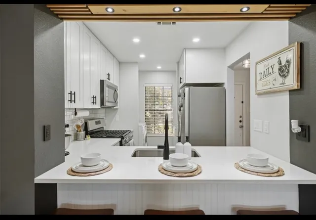 a kitchen with a sink and white cabinets