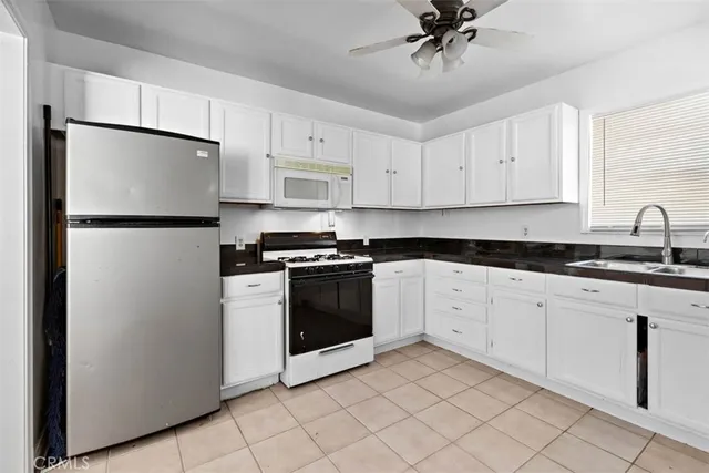 a kitchen with cabinets a refrigerator and a sink