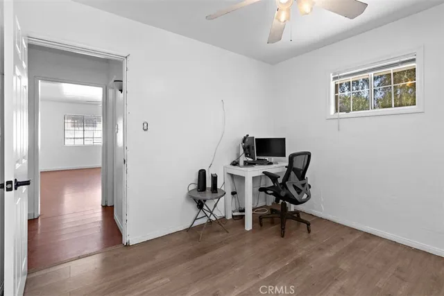 a view of a workspace with wooden floor and a window