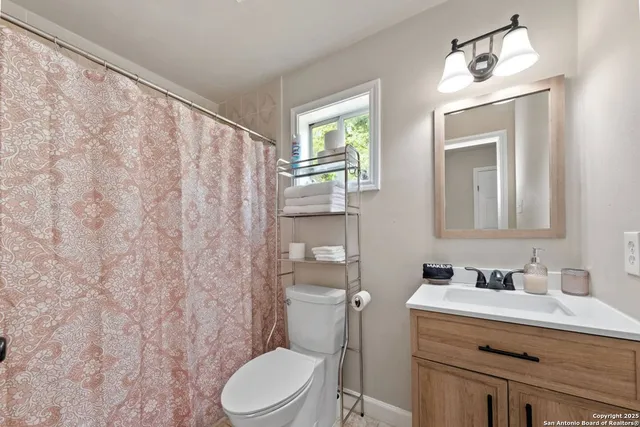 a bathroom with a sink a toilet and a mirror