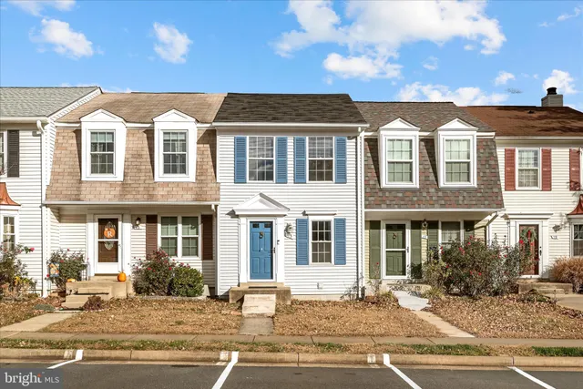 a view of a white building among the street and a tree