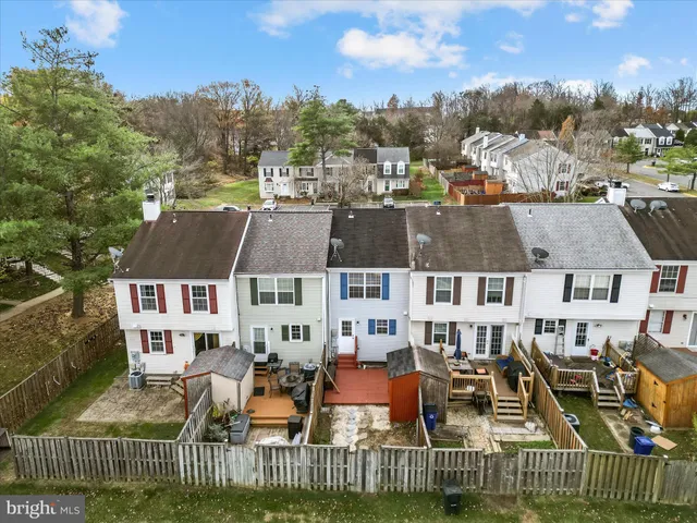 an aerial view of a house with wooden fence and large trees