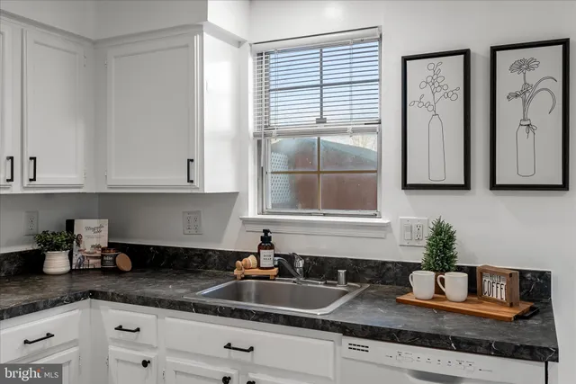 a kitchen with granite countertop a sink and cabinets