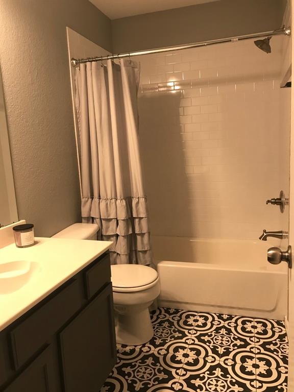 3305 Rustic Meadow Trail Mansfield, TX 76063 - Photo 10 of 12 Bathroom featuring patterned floor tiling, white subway-style shower surround, a built-in bathtub, a toilet, and a vanity with a countertop and undermount sink