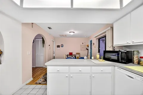 a room with kitchen island a sink stainless steel appliances and cabinets