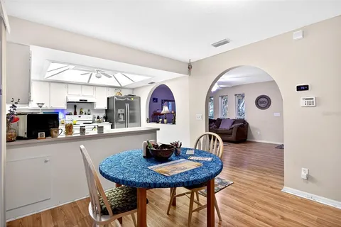 a kitchen with stainless steel appliances a dining table and chairs
