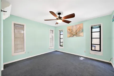 a view of a livingroom with a ceiling fan and window