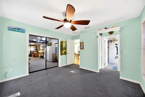 a view of a livingroom with a chandelier fan and a kitchen