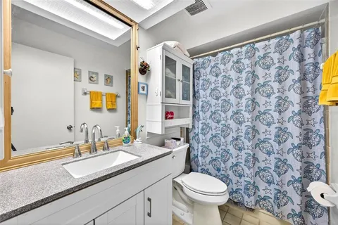 a bathroom with a granite countertop sink a toilet and a mirror