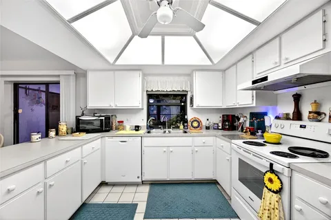 a kitchen with a sink a stove cabinets and counter space