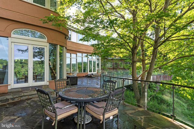 a backyard of a house with table and chairs under an umbrella