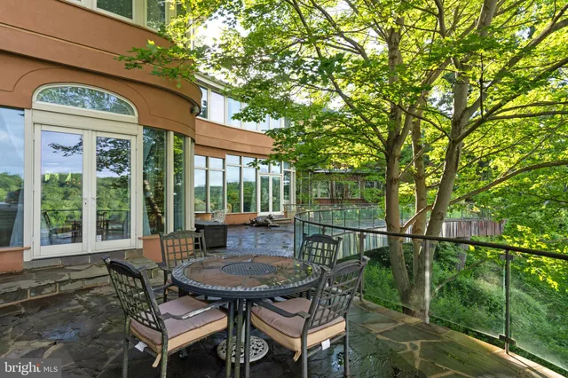 a backyard of a house with table and chairs under an umbrella