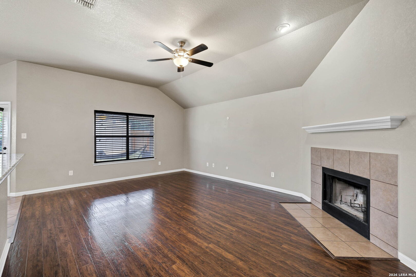 4015 Shervin Way Converse, TX 78109 - Photo 9 of 43 a view of an empty room with wooden floor fireplace and a window