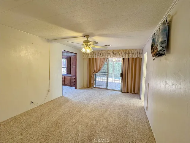 an empty room with closet and a chandelier fan