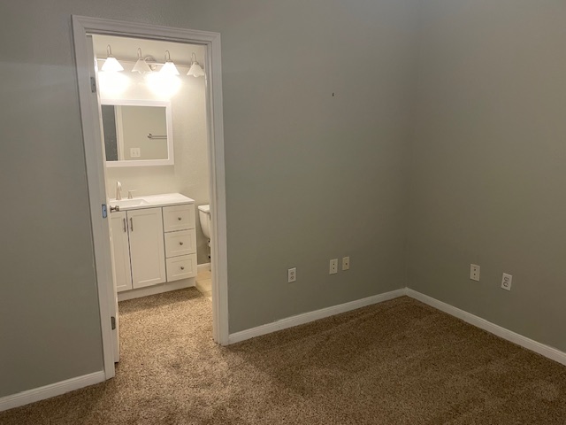 11203 Ranch Road 2222, Unit 703 Austin, TX 78732 - Photo 5 of 8 An inviting bedroom features plush carpeting and convenient direct access to an attached bathroom.