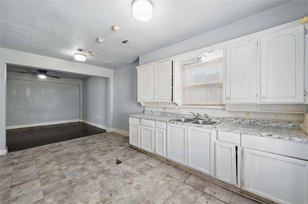 2813 East Rosedale Street Fort Worth, TX 76105 - Photo 17 of 23 a kitchen with granite countertop a sink and cabinets