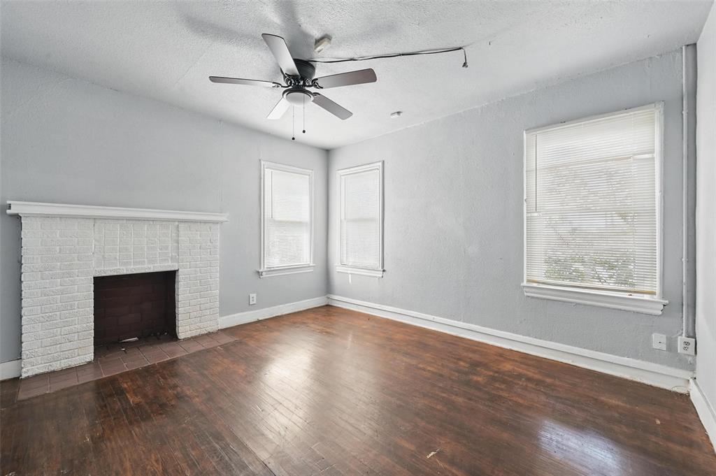 2813 East Rosedale Street Fort Worth, TX 76105 - Photo 6 of 23 an empty room with wooden floor fireplace and windows