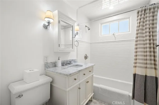 a bathroom with a sink toilet vanity and tub