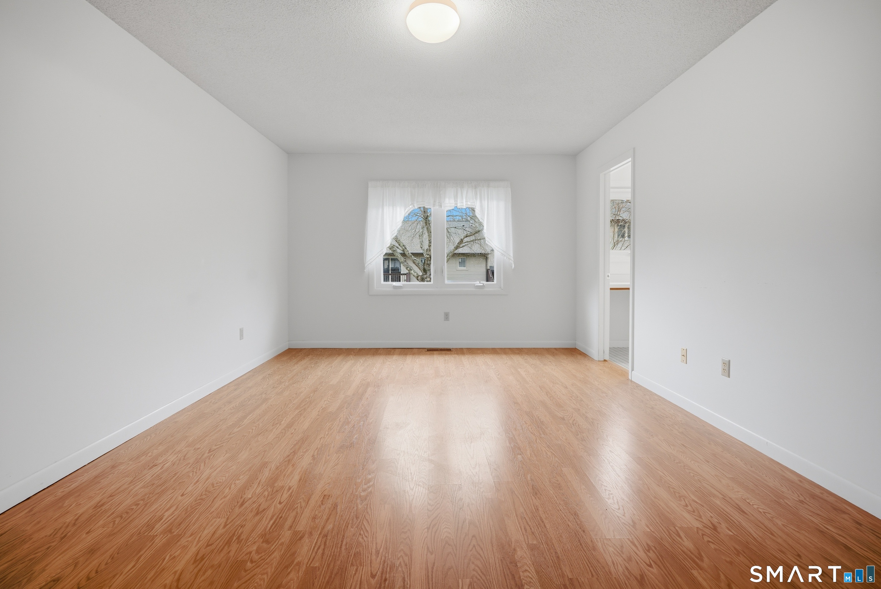 449 South Main Street, Unit 90 Manchester, CT 06040 - Photo 25 of 39 an empty room with wooden floor and windows