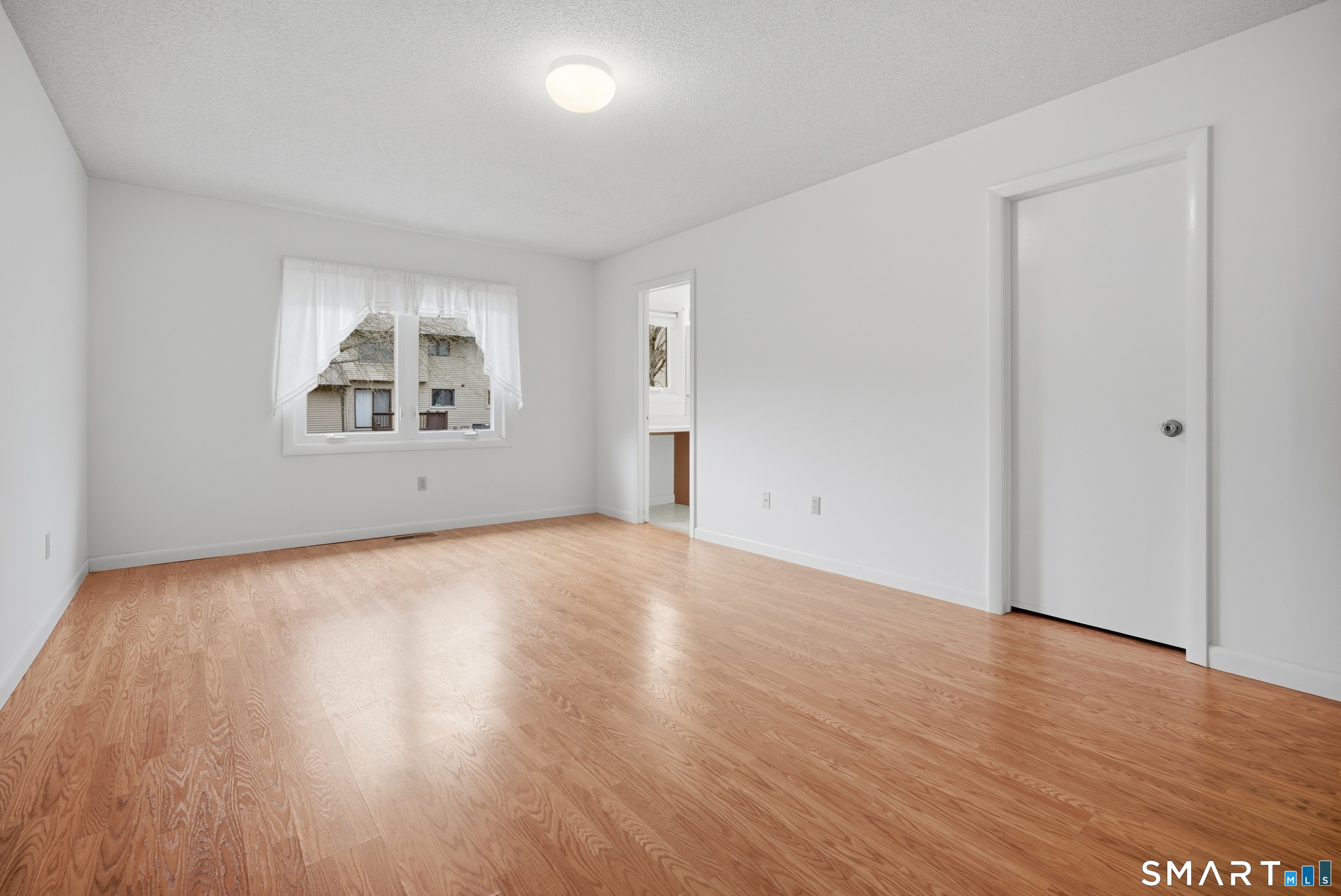 449 South Main Street, Unit 90 Manchester, CT 06040 - Photo 26 of 39 an empty room with wooden floor and windows