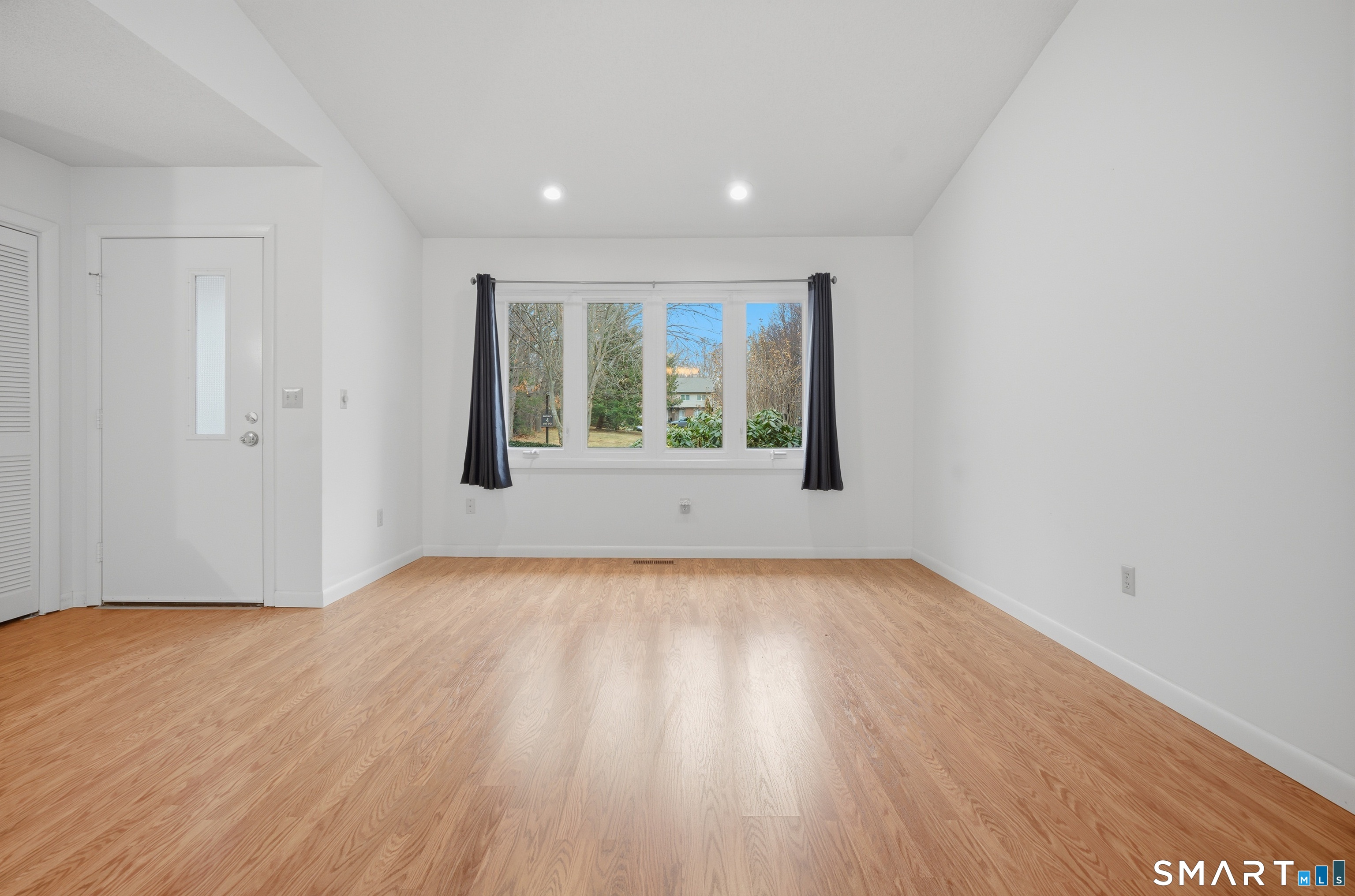 449 South Main Street, Unit 90 Manchester, CT 06040 - Photo 5 of 39 a view of an empty room with wooden floor and a window