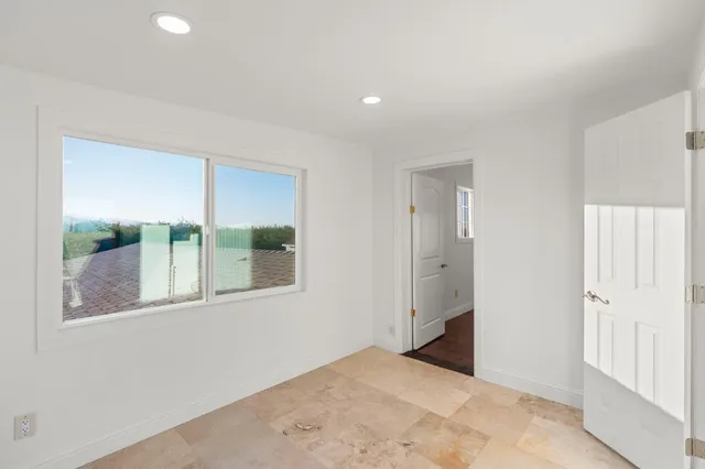 an empty room with a window and a bathroom