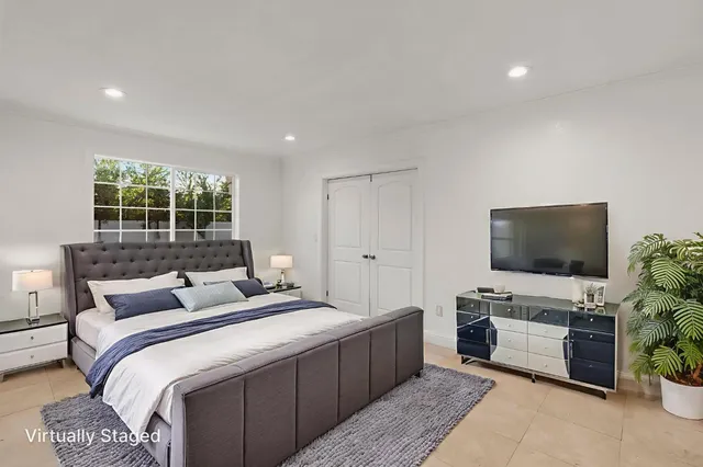 a bedroom with a bed and a flat screen tv