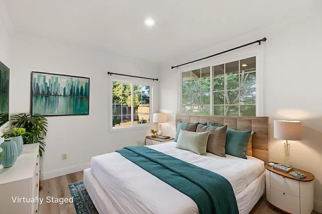 a bedroom with a large bed and a potted plant