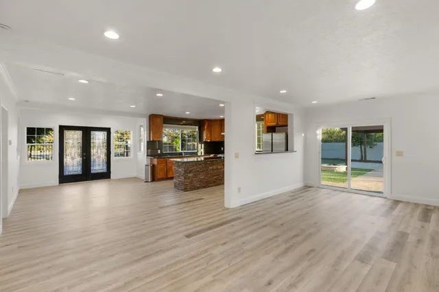 an empty room with wooden floor and windows