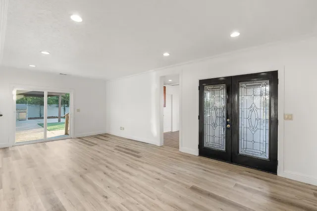 an empty room with wooden floor and windows