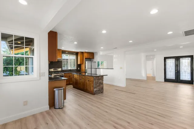 a kitchen with stainless steel appliances kitchen island granite countertop a stove a sink a refrigerator and a microwave