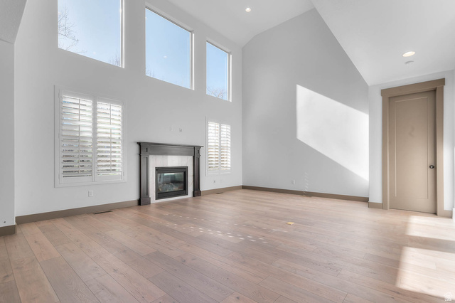 2724 Mt Jordan Road Sandy, UT 84092 - Photo 11 of 33 Unfurnished living room featuring a glass covered fireplace, light wood-style floors, vaulted ceiling, and recessed lighting