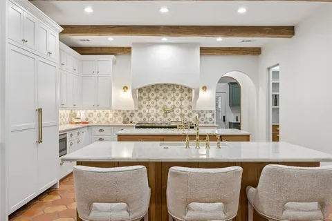 a kitchen with stainless steel appliances granite countertop a table and chairs in it