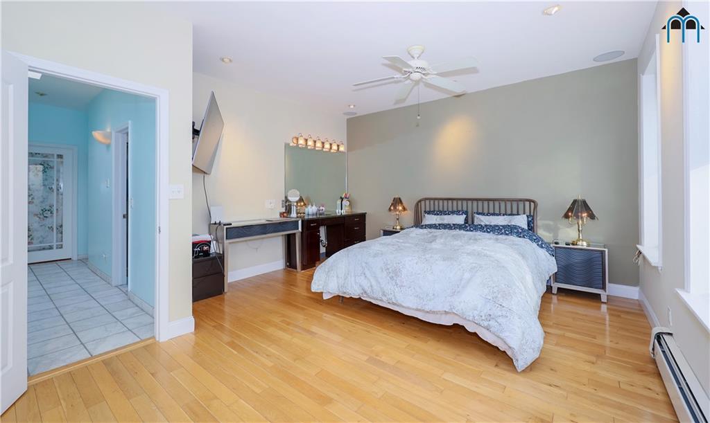 8909 Ridge Boulevard Brooklyn, NY 11209 - Photo 13 of 31 a bedroom with a bed and wooden floor