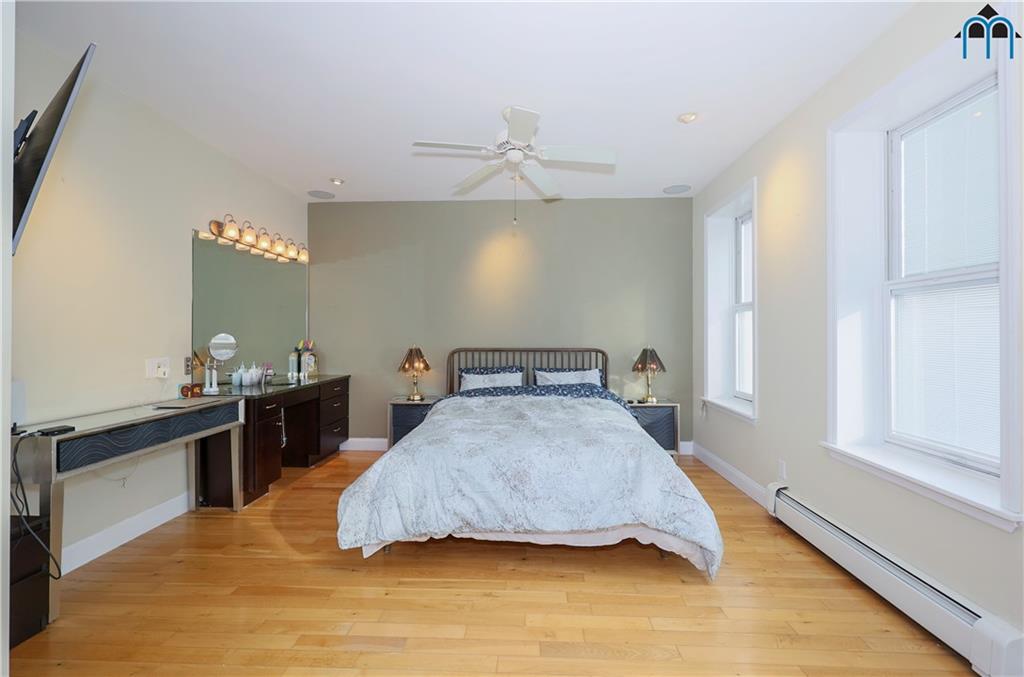 8909 Ridge Boulevard Brooklyn, NY 11209 - Photo 14 of 31 a bedroom with a bed and dresser with mirror