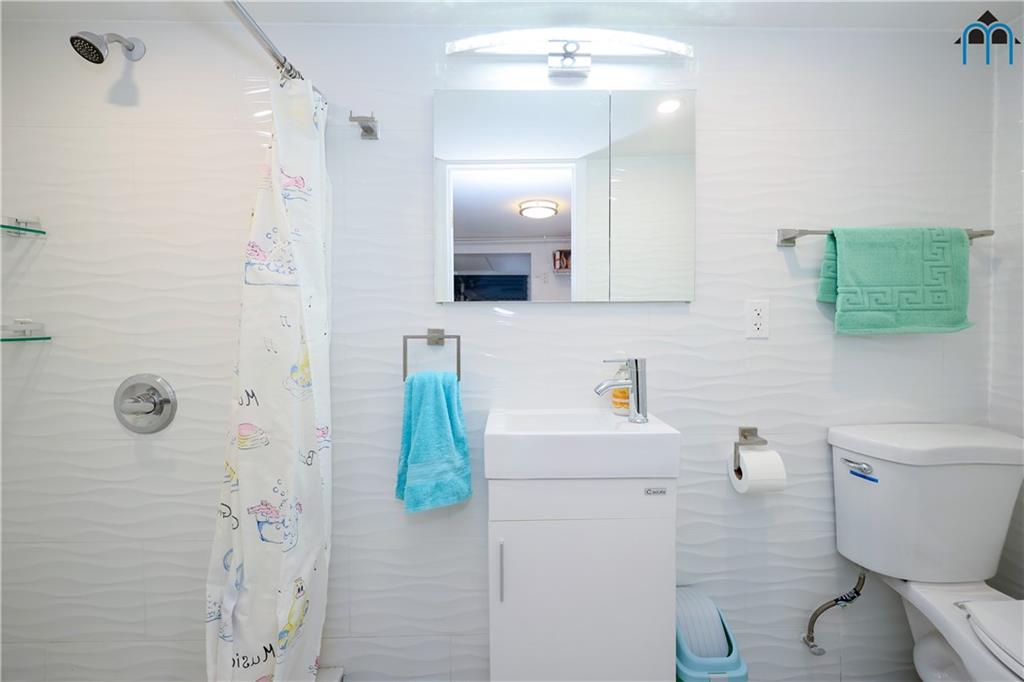8909 Ridge Boulevard Brooklyn, NY 11209 - Photo 23 of 31 a bathroom with a sink a toilet and shower