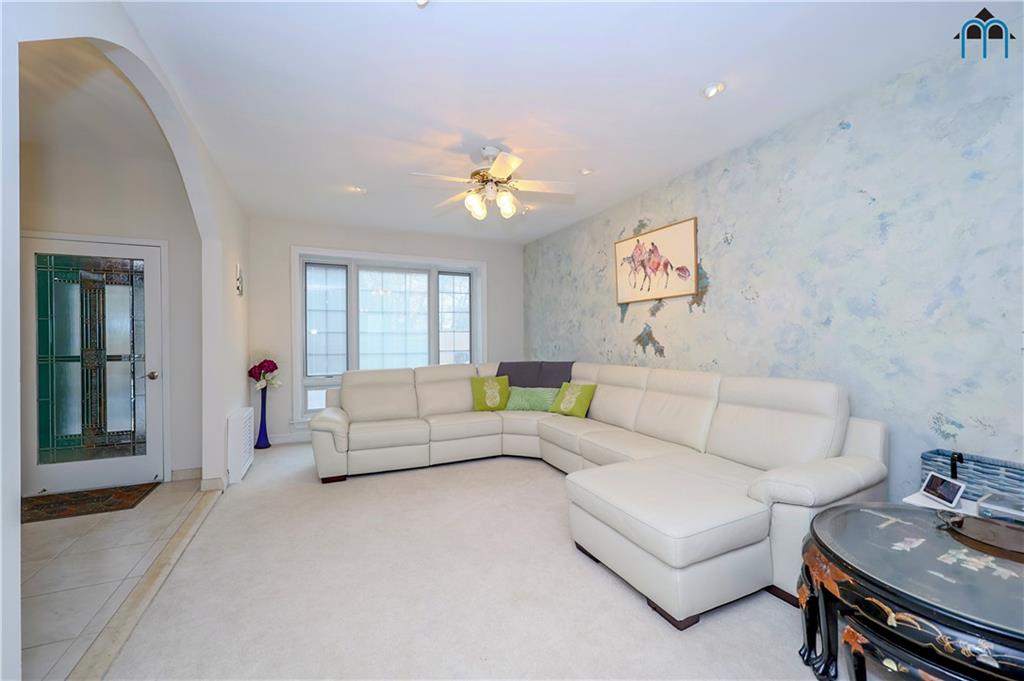 8909 Ridge Boulevard Brooklyn, NY 11209 - Photo 9 of 31 a living room with furniture a chandelier and a window
