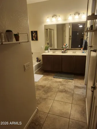 a bathroom with a tub a sink and a mirror