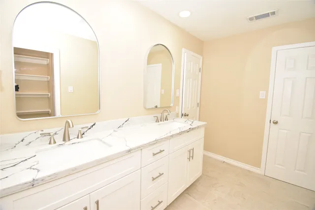 a bathroom with a double vanity sink and a mirror