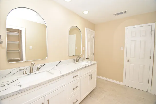 a bathroom with a double vanity sink and a mirror