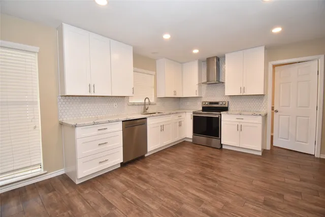 a kitchen with granite countertop white cabinets and white appliances