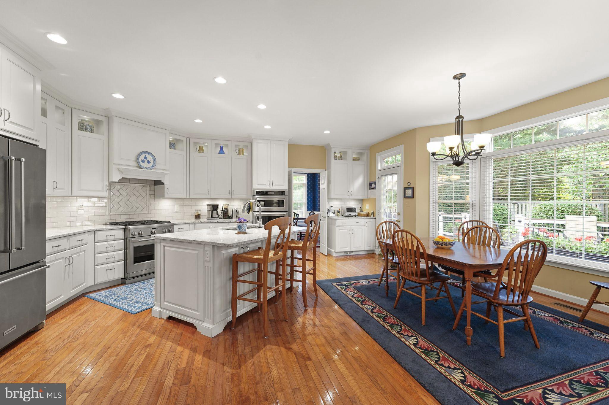 6651 Avignon Boulevard Falls Church, VA 22043 - Photo 17 of 51 a kitchen with stainless steel appliances granite countertop a stove a sink dishwasher a refrigerator a dining table and chairs with wooden floor