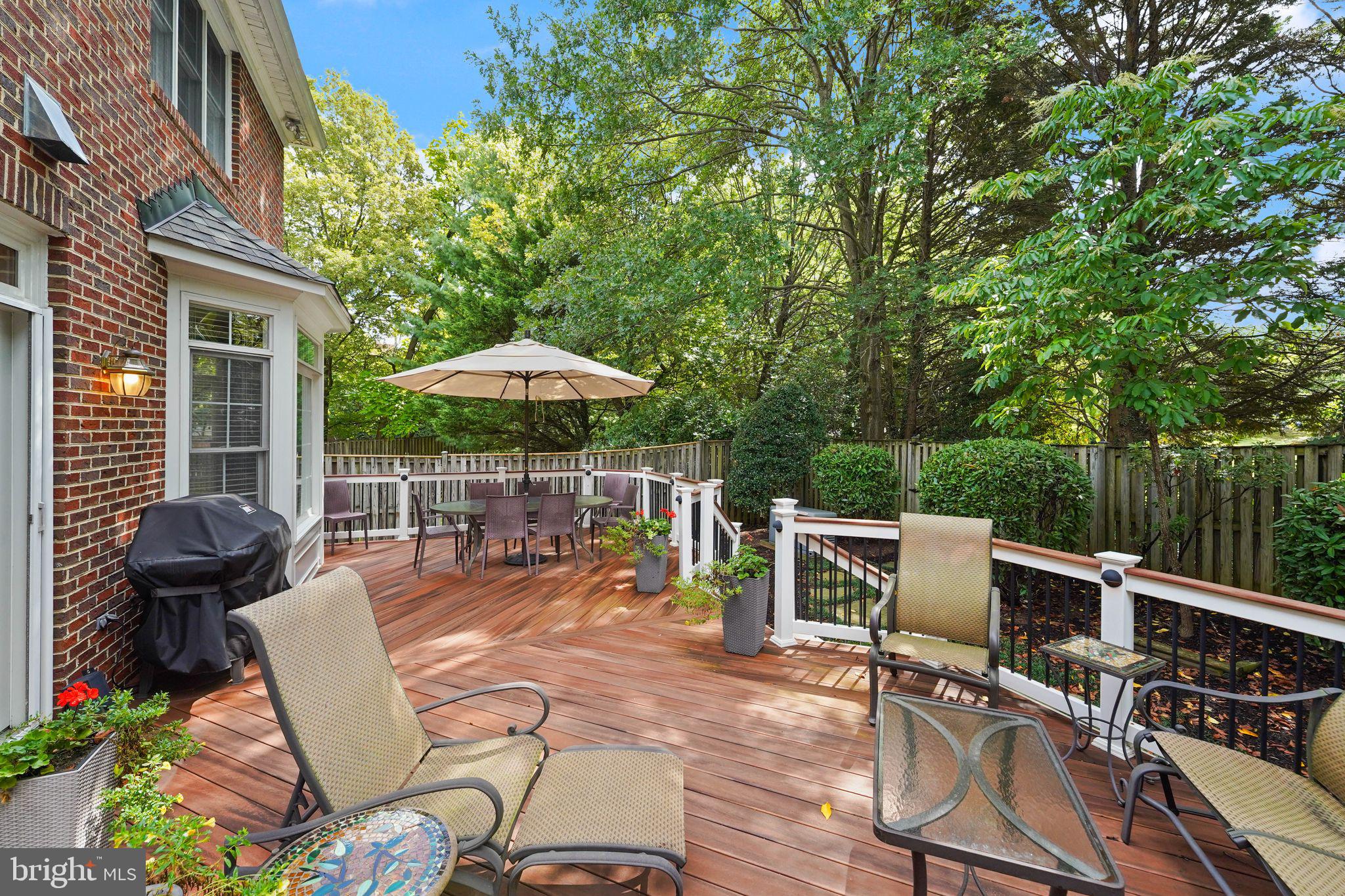 6651 Avignon Boulevard Falls Church, VA 22043 - Photo 43 of 51 a view of a patio with a dining table and chairs under an umbrella with wooden fence