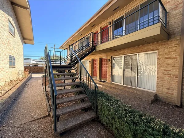 a view of a house with wooden stairs and floor to ceiling window