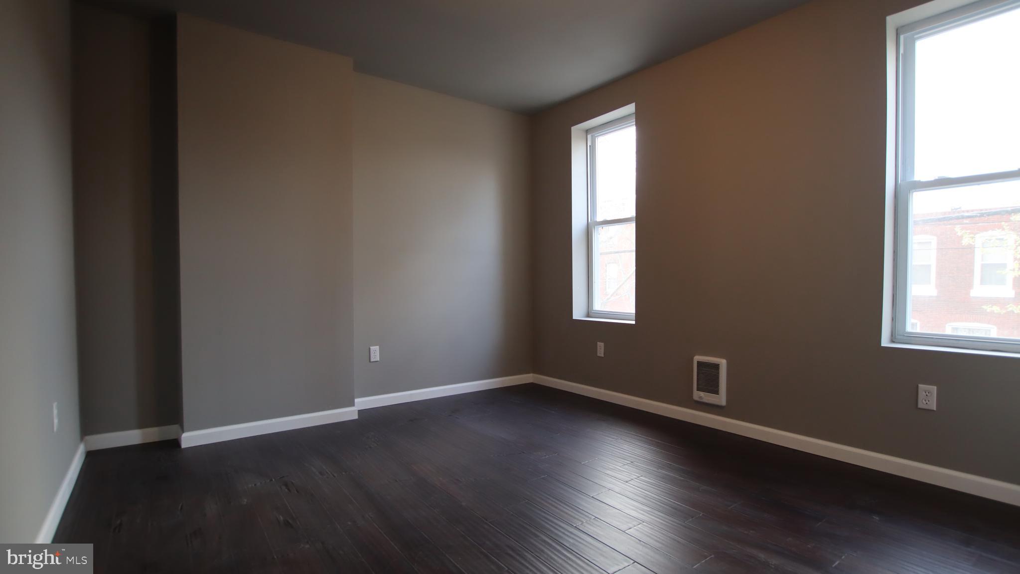 4932 West Thompson Street, Unit 2 Philadelphia, PA 19131 - Photo 13 of 24 an empty room with wooden floor and windows