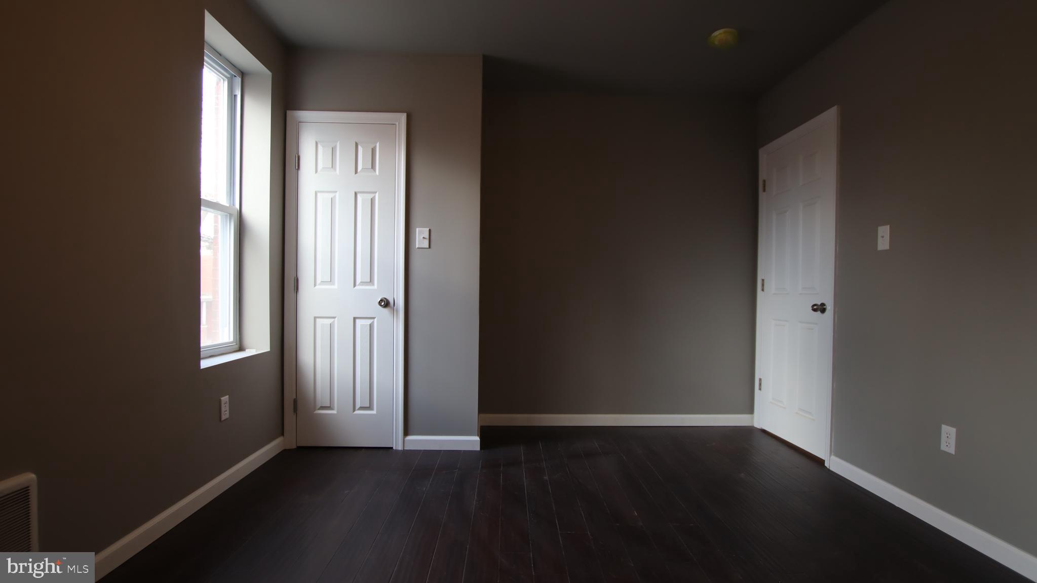 4932 West Thompson Street, Unit 2 Philadelphia, PA 19131 - Photo 14 of 24 an empty room with wooden floor and windows