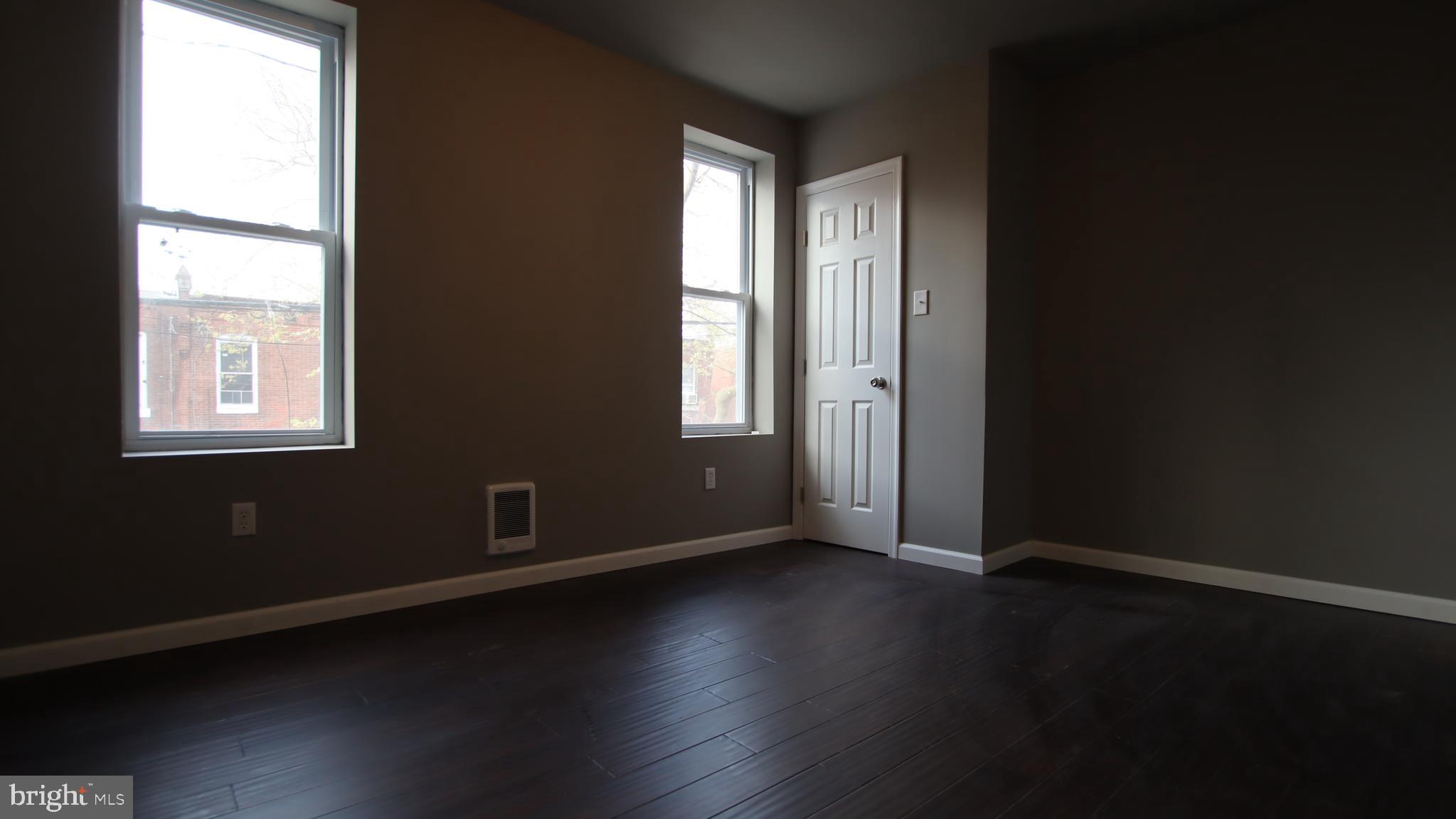 4932 West Thompson Street, Unit 2 Philadelphia, PA 19131 - Photo 15 of 24 an empty room with wooden floor and windows