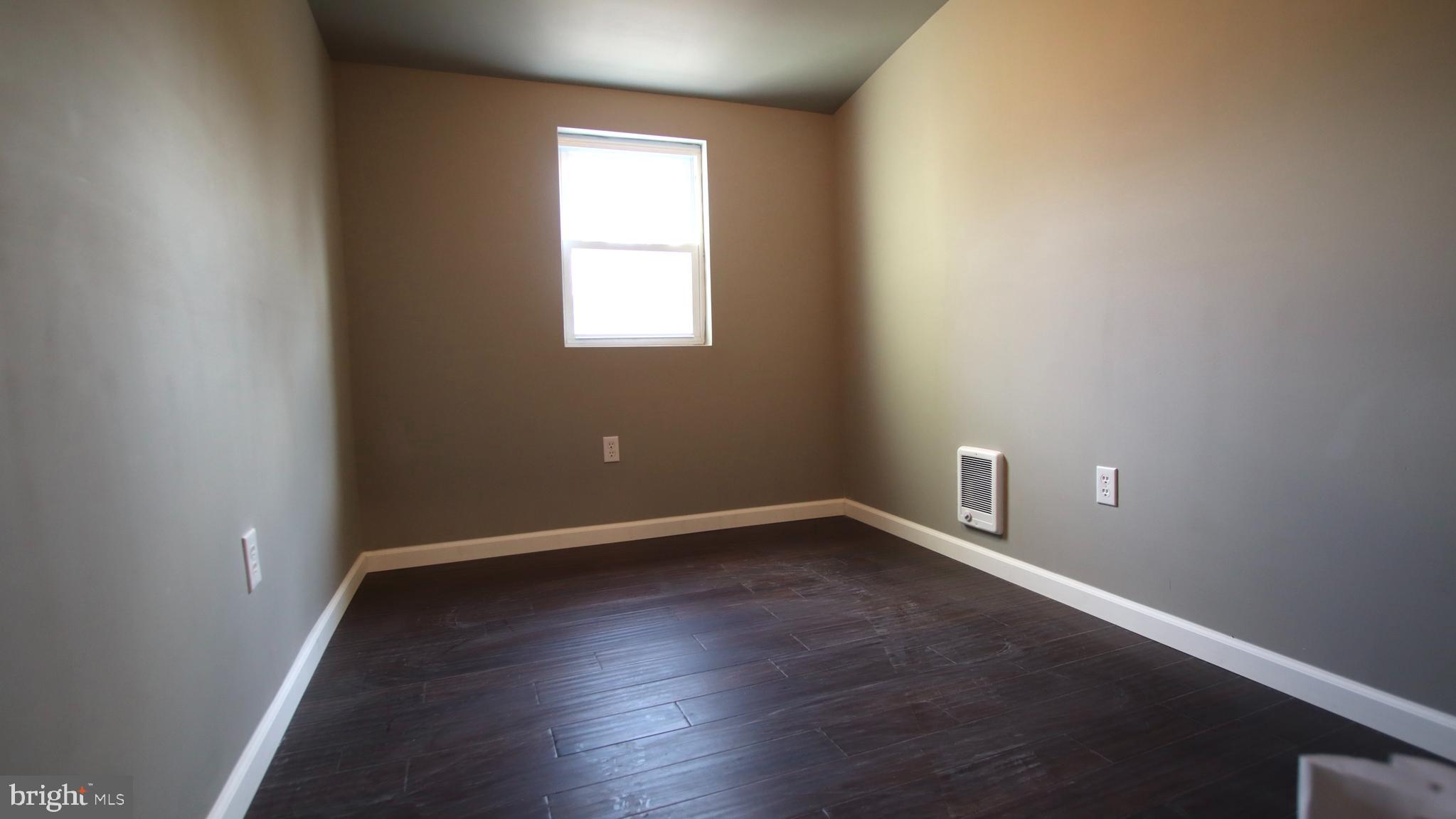 4932 West Thompson Street, Unit 2 Philadelphia, PA 19131 - Photo 16 of 24 an empty room with wooden floor and windows