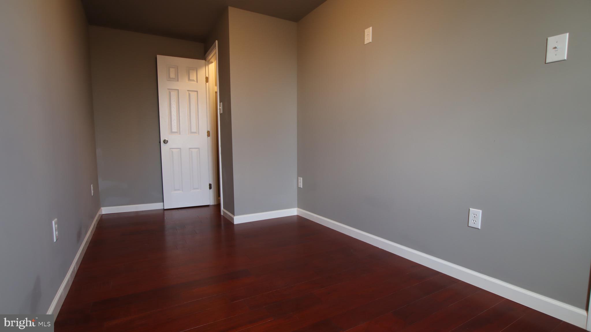 4932 West Thompson Street, Unit 2 Philadelphia, PA 19131 - Photo 18 of 24 an empty room with wooden floor and windows