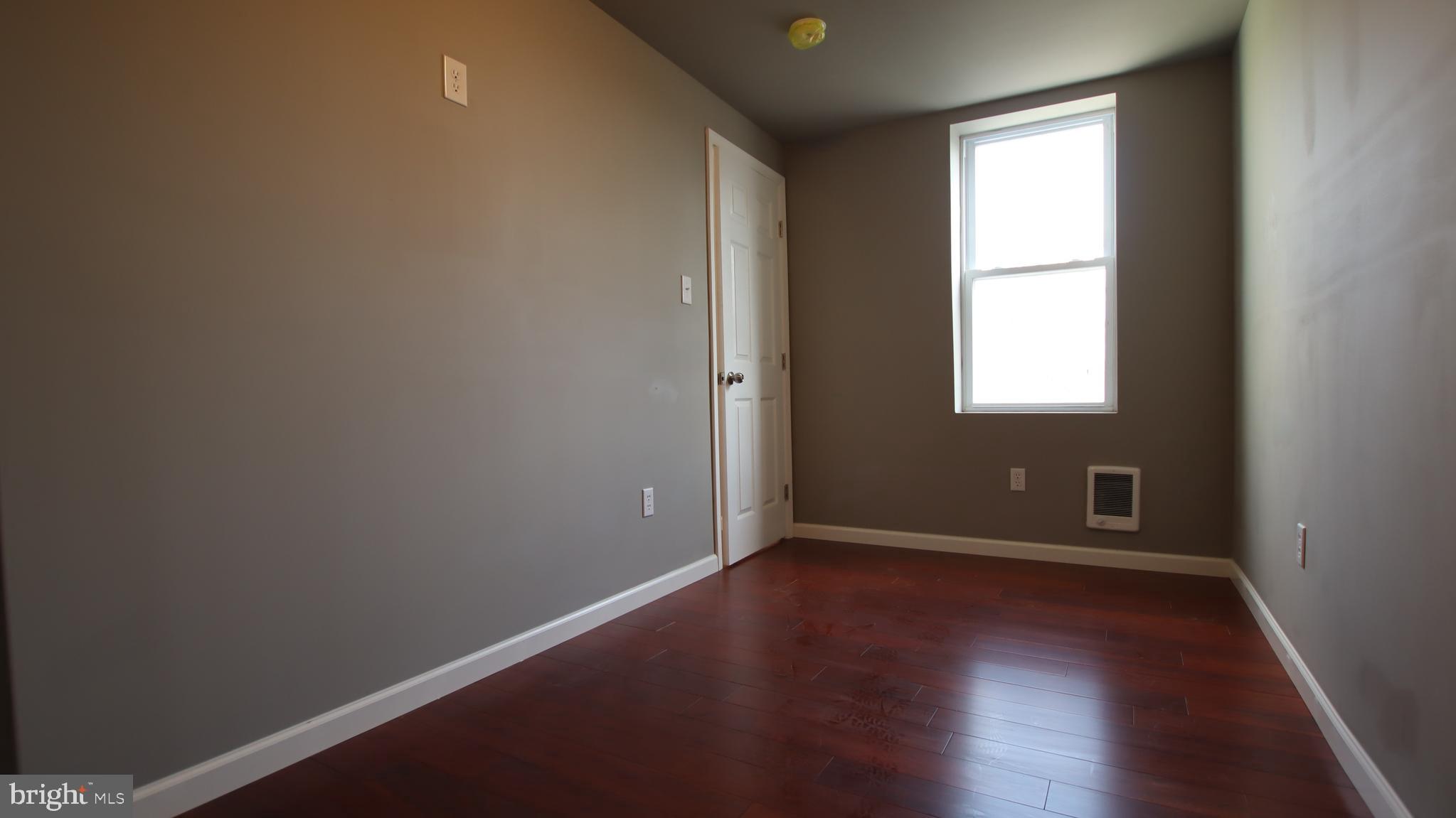 4932 West Thompson Street, Unit 2 Philadelphia, PA 19131 - Photo 19 of 24 an empty room with wooden floor and windows